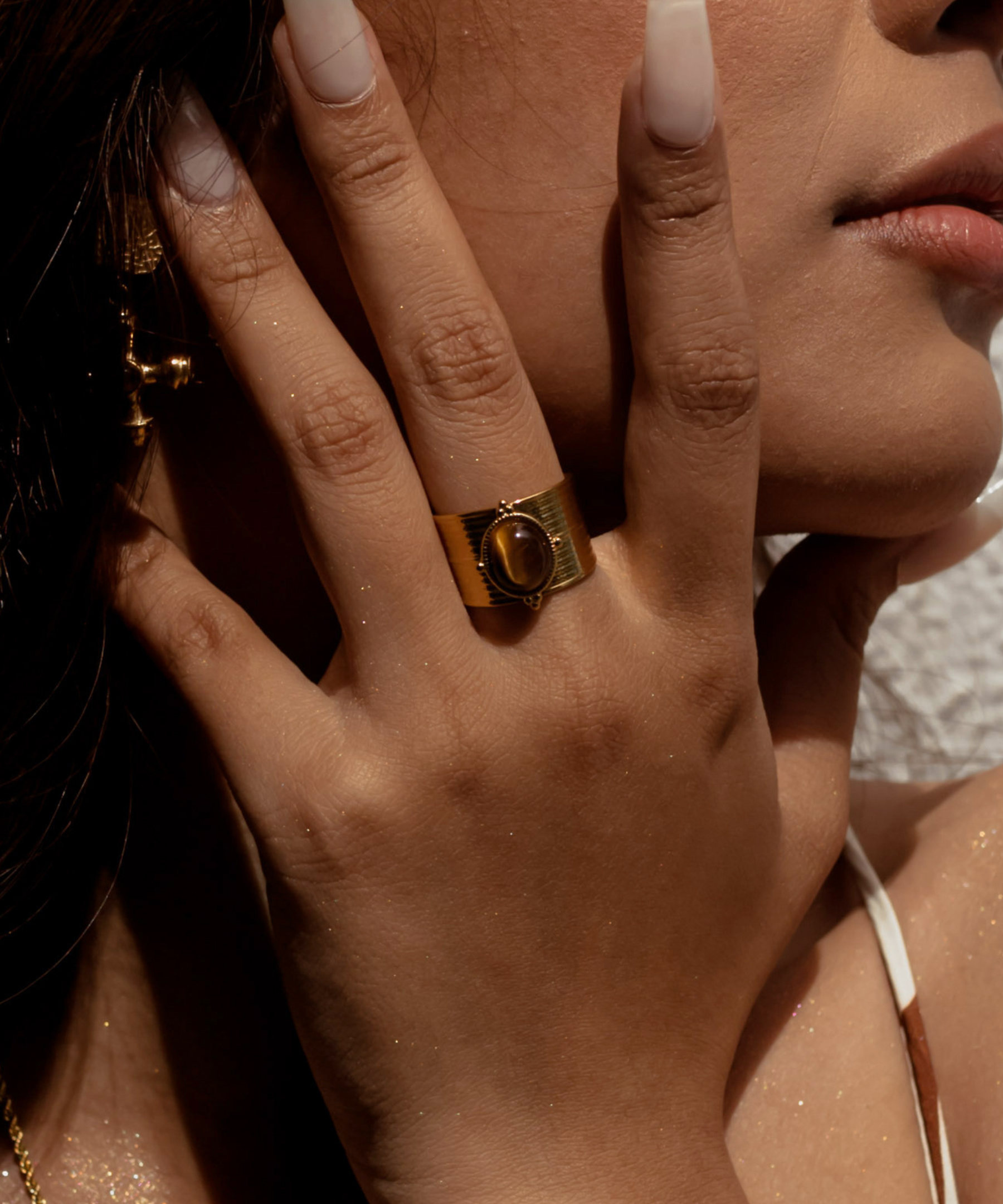 Closeup of model wearing Sola Ring with tiger eye centerpiece.
