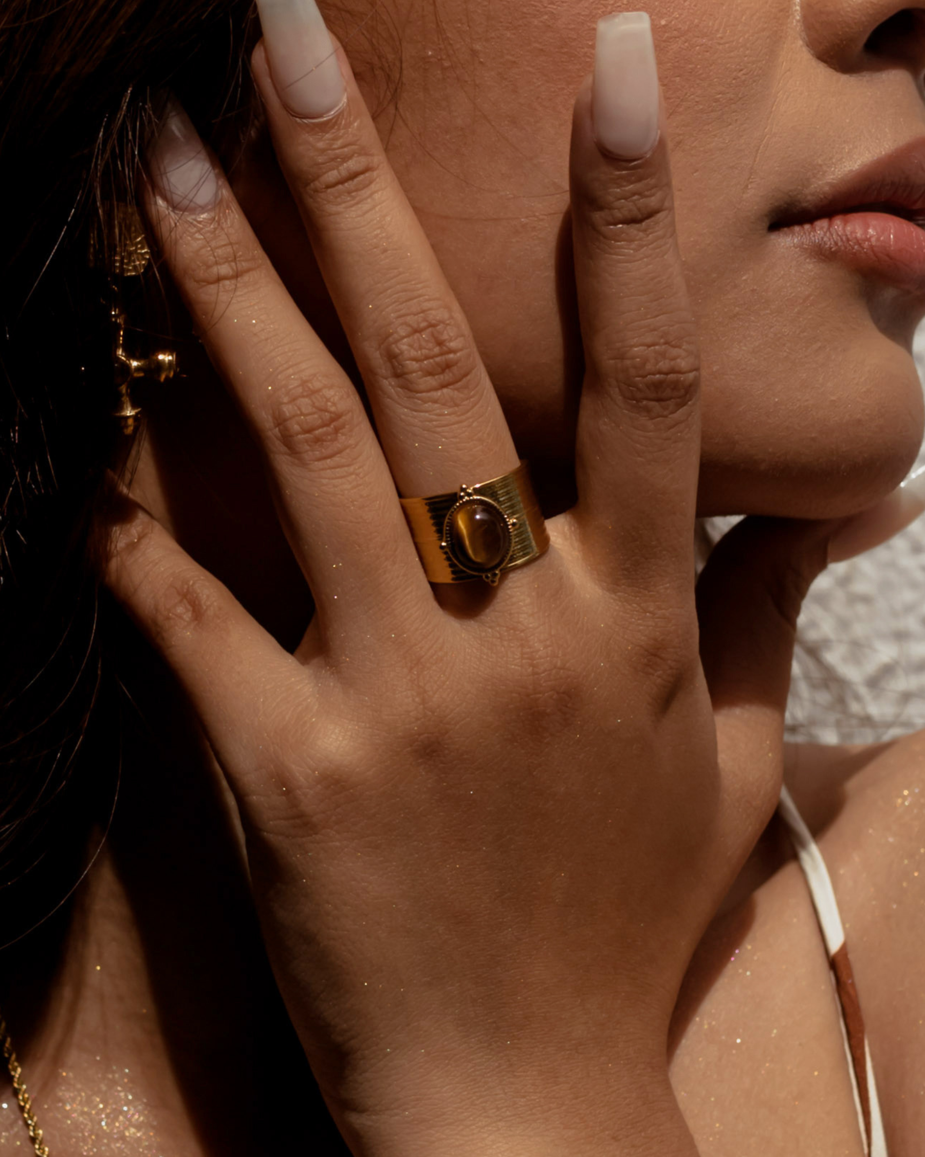 Closeup of model wearing Sola Ring with tiger eye centerpiece.