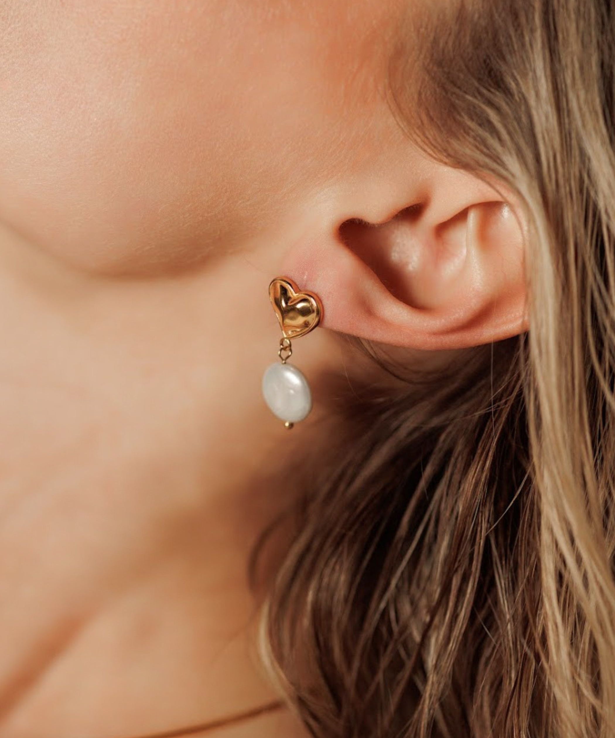 Close-up of Valentina Earrings worn, showcasing pearl and heart design.