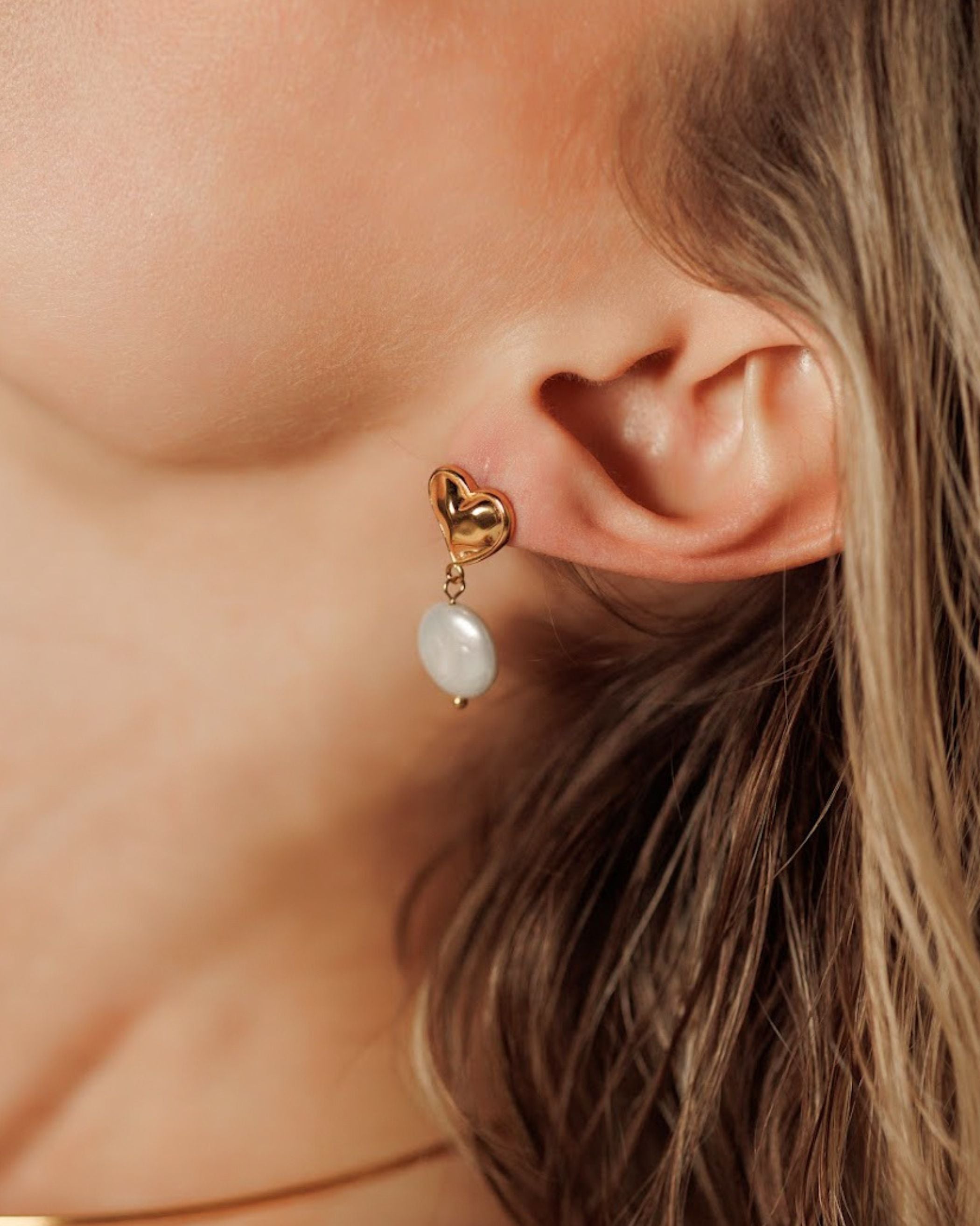 Close-up of Valentina Earrings worn, showcasing pearl and heart design.