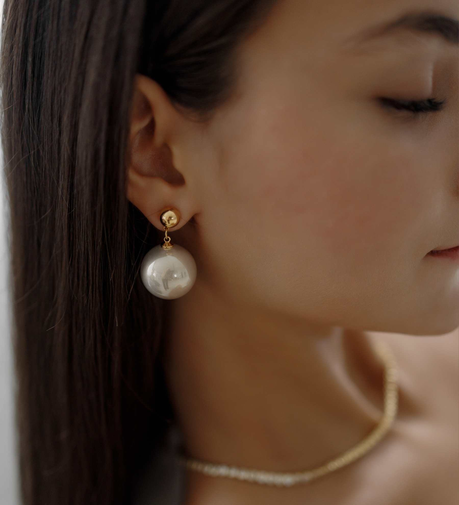 Close-up of Zaila Earrings worn, featuring elegant faux pearl drop.