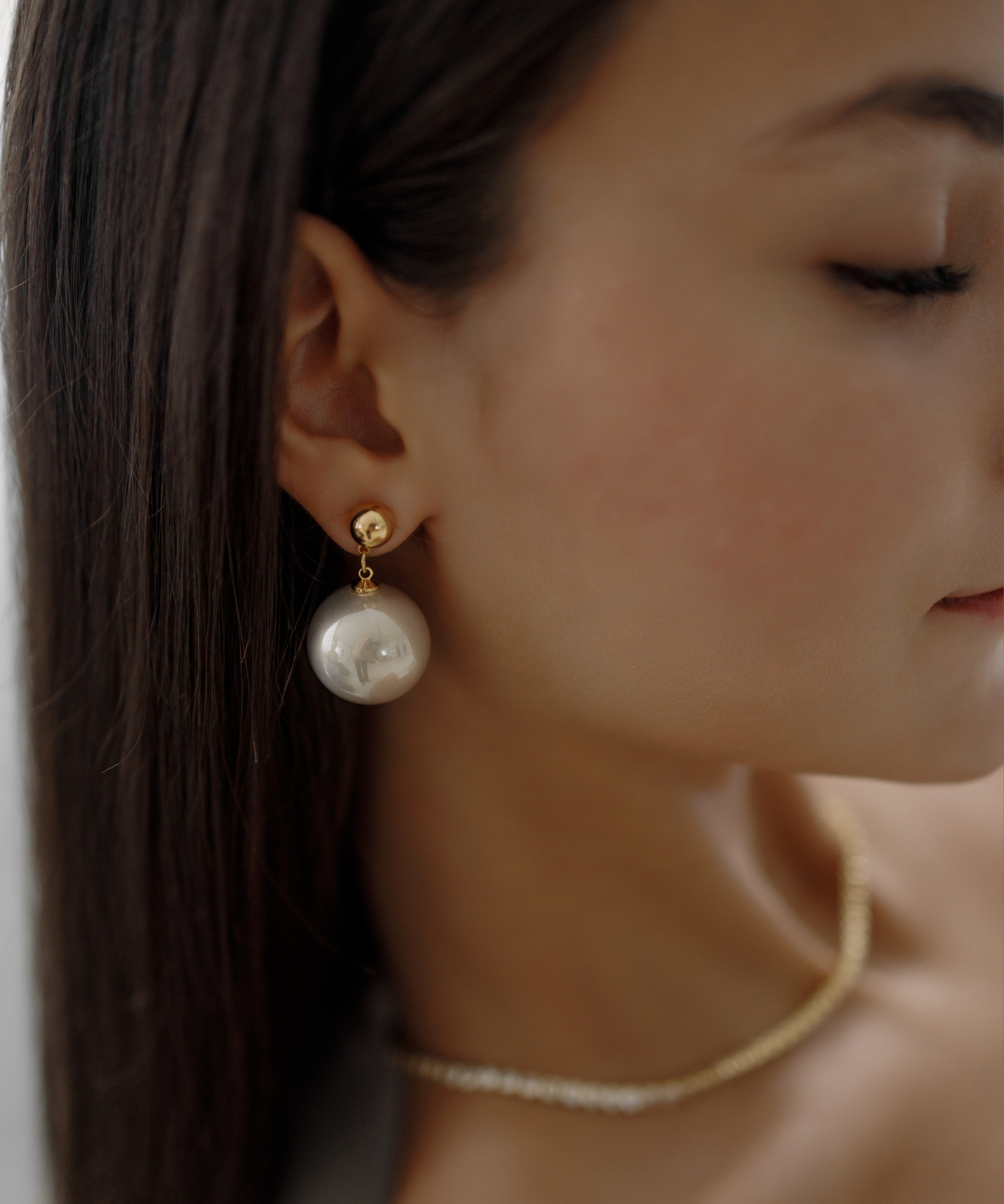 Close-up of Zaila Earrings worn, featuring elegant faux pearl drop.