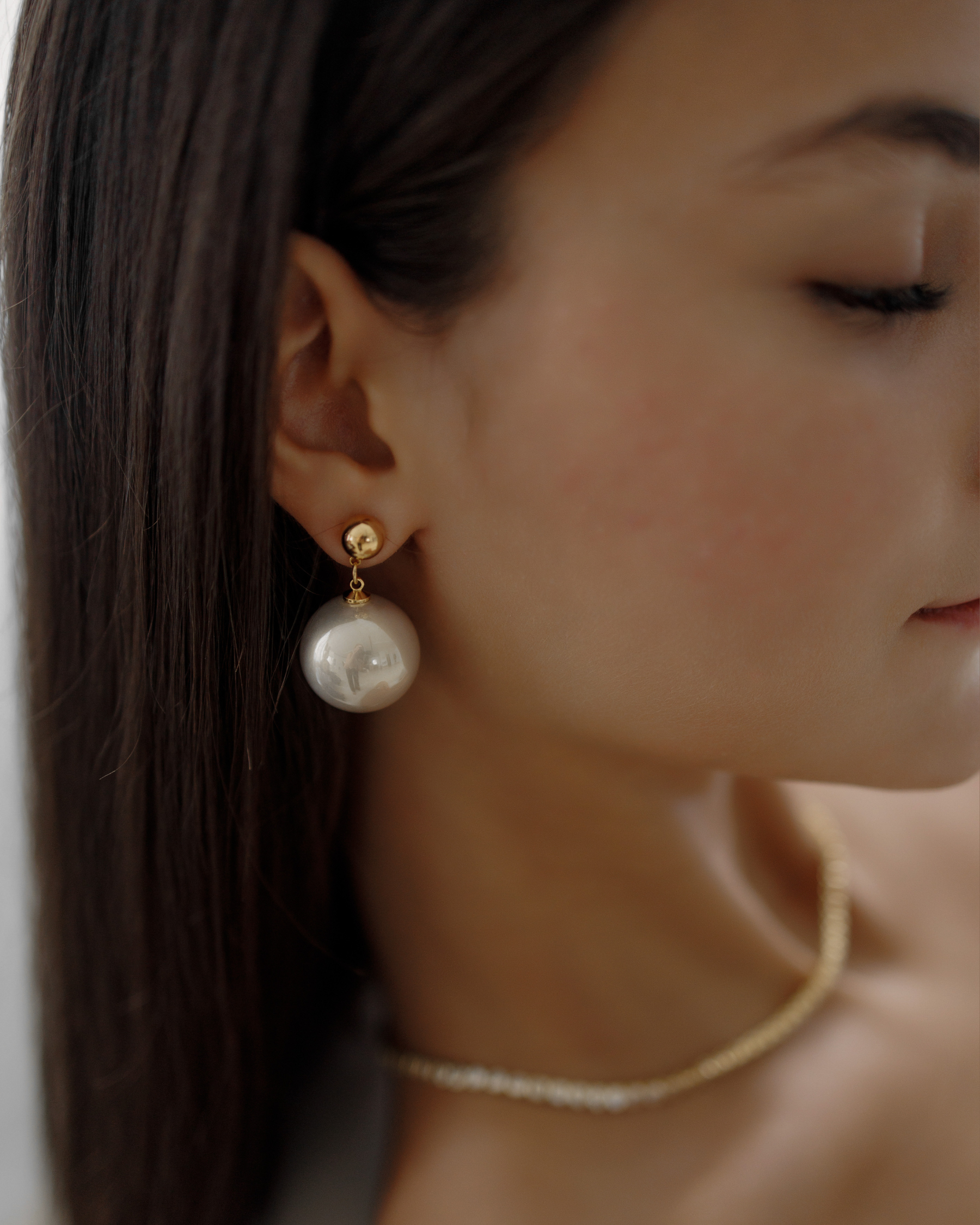 Close-up of Zaila Earrings worn, featuring elegant faux pearl drop.