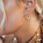 Closeup view of Belle Earrings worn, showing 360° zirconia sparkle.
