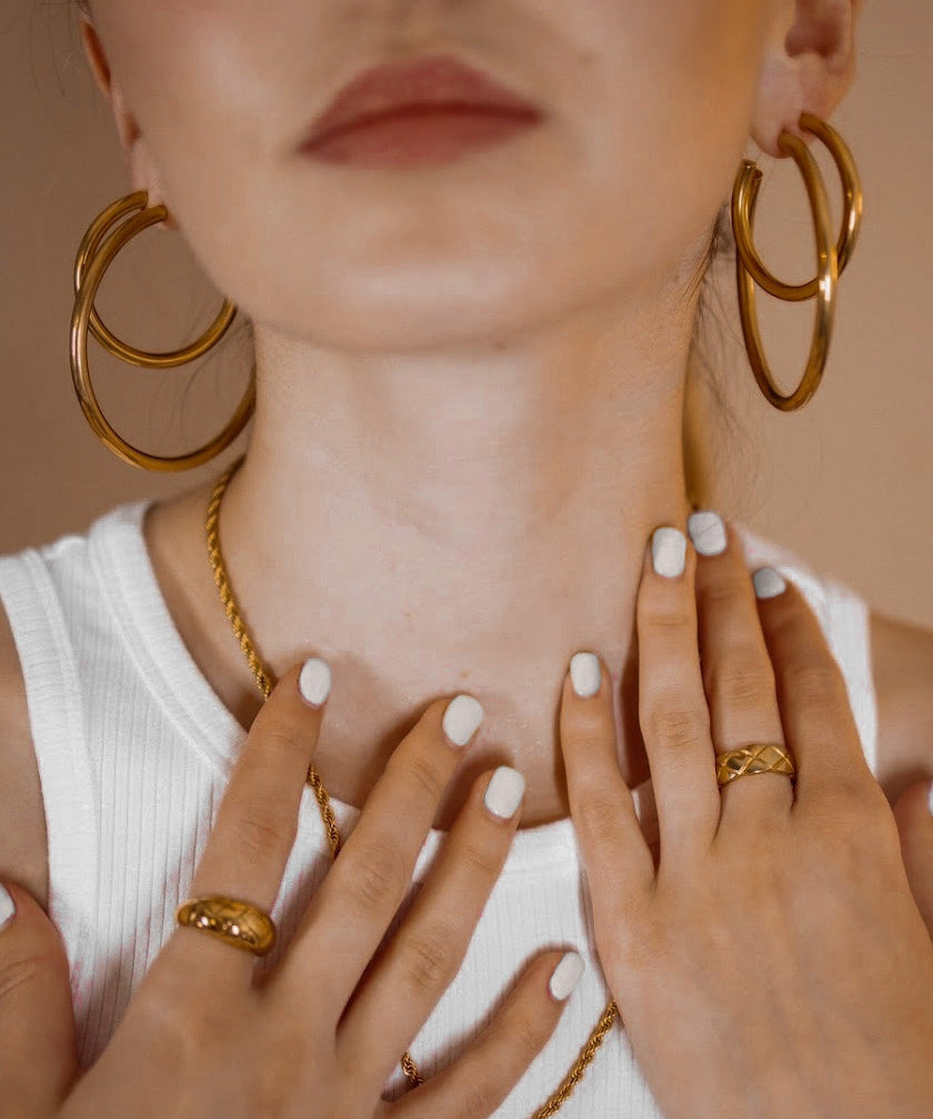 Closeup of Callista Earrings showcasing the bold yet timeless gold hoop design.