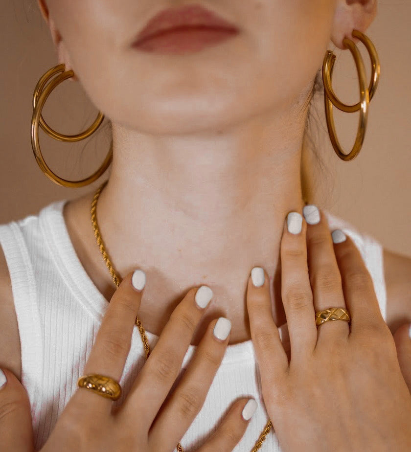 Closeup of Callista Earrings showcasing the bold yet timeless gold hoop design.