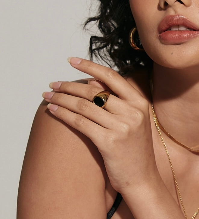 Closeup view of Caro Ring worn, highlighting its bold black enamel centerpiece.