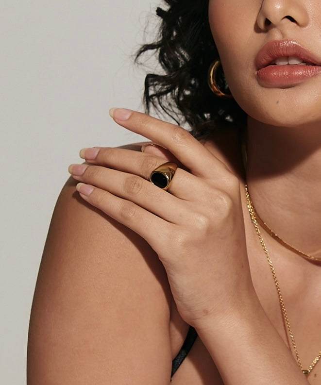 Closeup view of Caro Ring worn, highlighting its bold black enamel centerpiece.