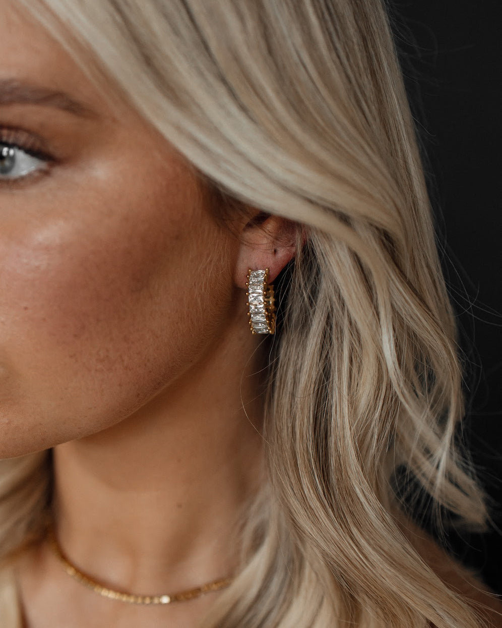 Closeup of Ciana Earrings worn, showing semi hoop zirconia sparkle.