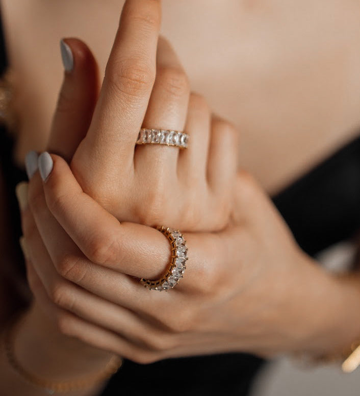 Close-up of hand wearing the Ciana Ring, showing its fine gold band and shimmering zirconia