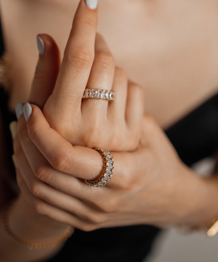 Close-up of hand wearing the Ciana Ring, showing its fine gold band and shimmering zirconia