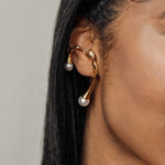 Closeup view of Dahlia Ear Cuff worn on ear showing pearl accents and branch design.