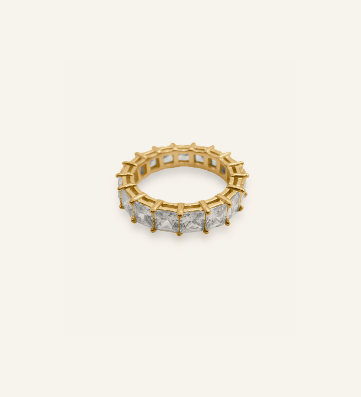 Elia Ring product flatlay showing gold infinity band with square zirconia stones.