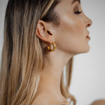 Worn Gaia Earrings shown from the side, capturing tropical chic elegance.