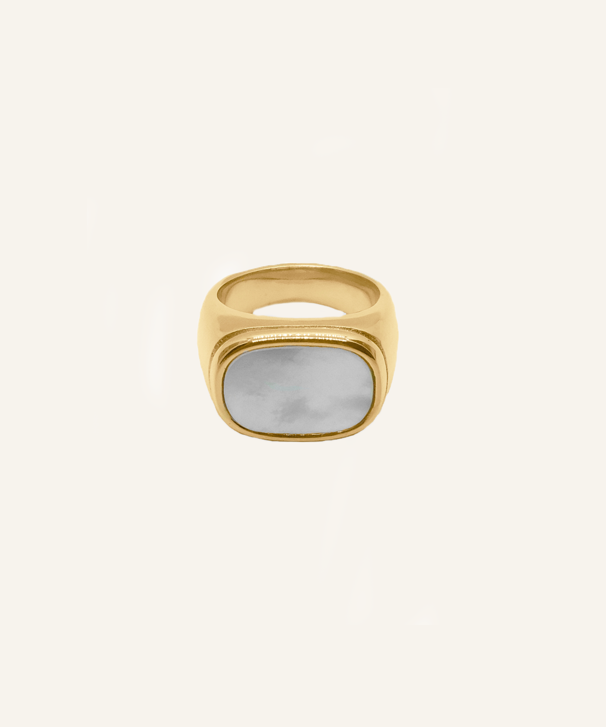 Flatlay of the Kai Ring showing chunky gold band with white cowry shell.