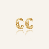Product flatlay of Kalani Earrings showing gold Cuban link huggie design.