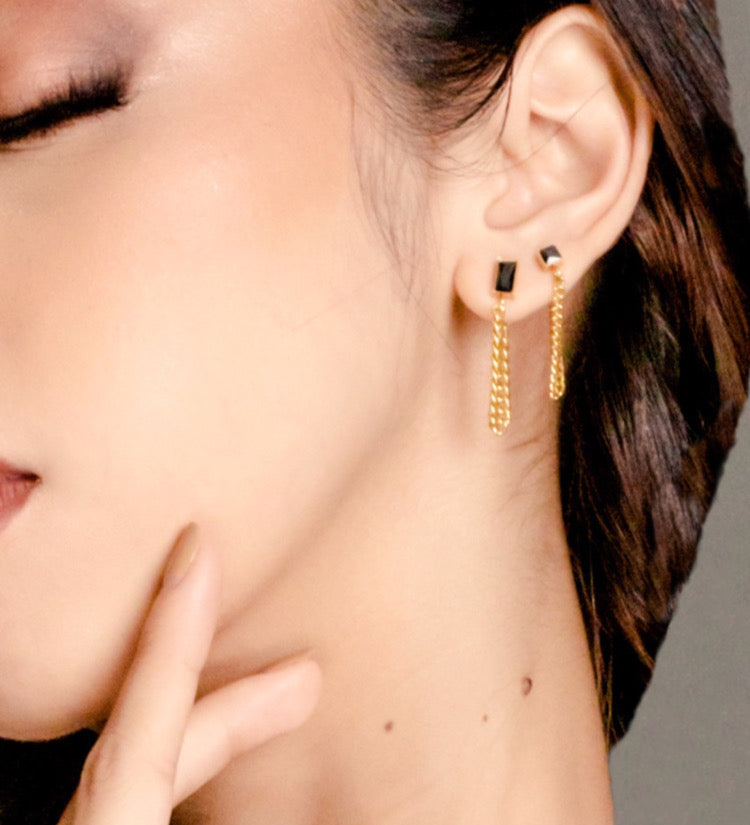 Closeup of Laurie Earrings worn, showing elegant gold and black onyx drop.