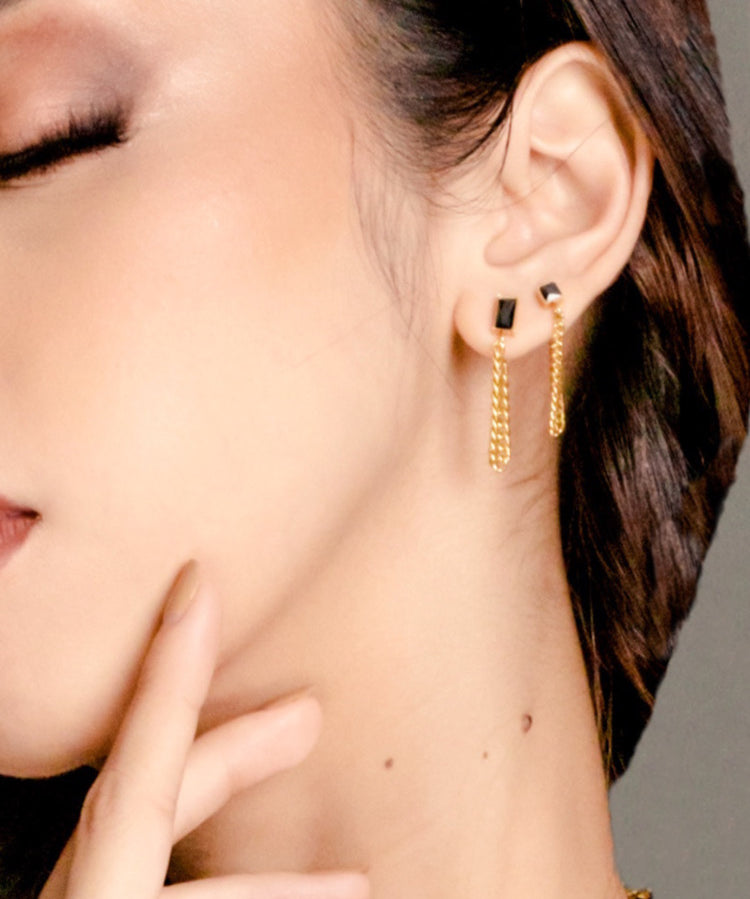 Closeup of Laurie Earrings worn, showing elegant gold and black onyx drop.