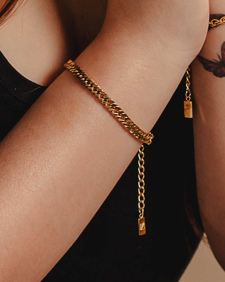 Closeup view of Leo Bracelet worn on wrist, showing its bold and sleek gold chain.