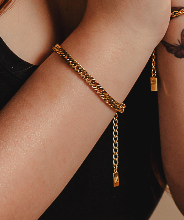 Closeup view of Leo Bracelet worn on wrist, showing its bold and sleek gold chain.