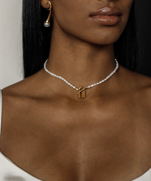 Closeup view of the Lily Necklace on neck highlighting padlock pendant and pearl choker design.