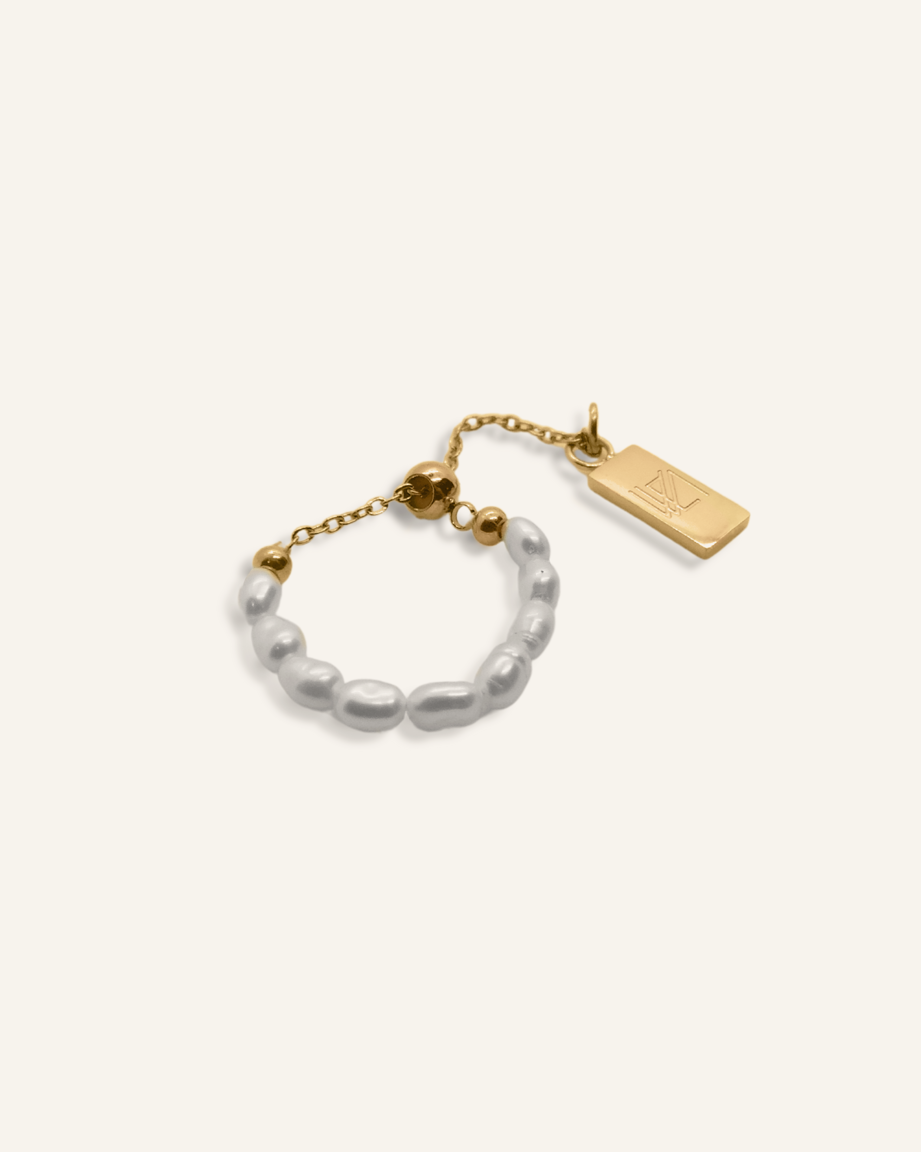 Neya Ring featuring a delicate pearl band with gold chain and accent charm.