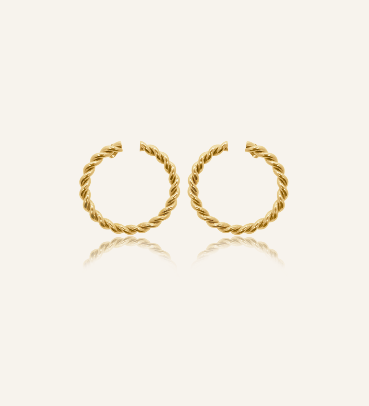 Selene Earrings flatlay showing twisted circular gold hoop design.