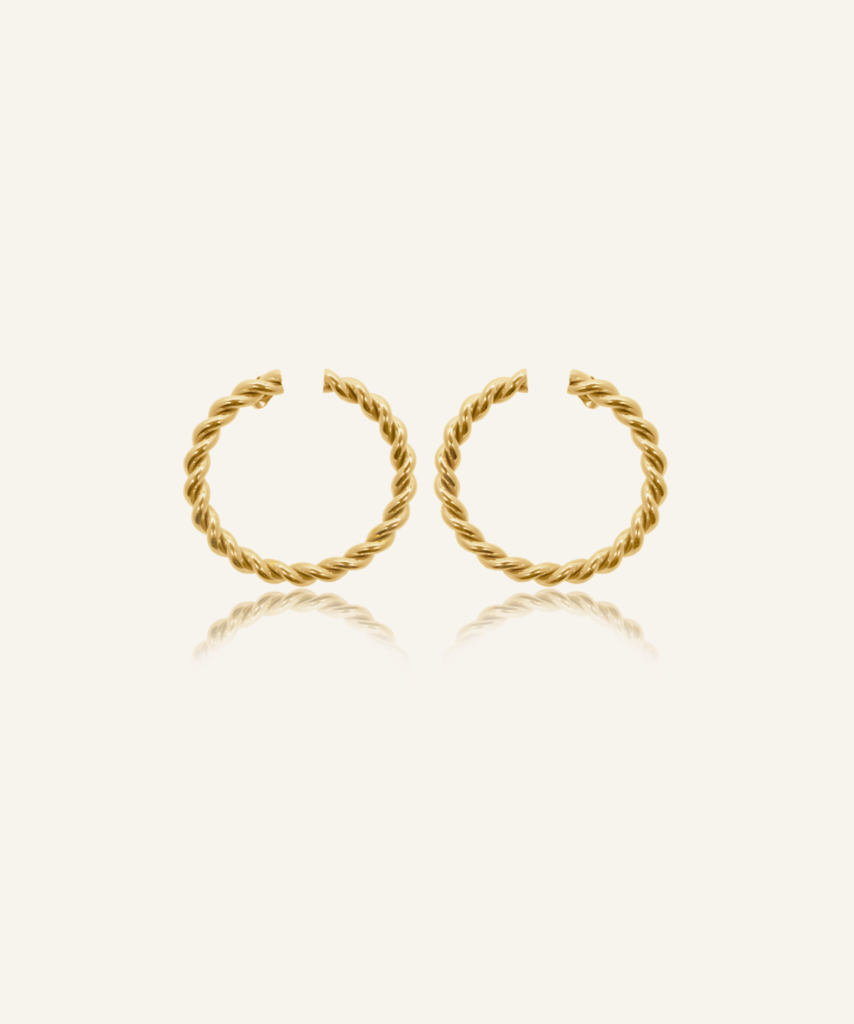 Selene Earrings flatlay showing twisted circular gold hoop design.