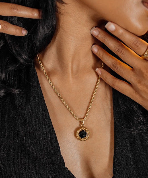 Closeup of the Valeriana Necklace worn, highlighting gold and onyx details.